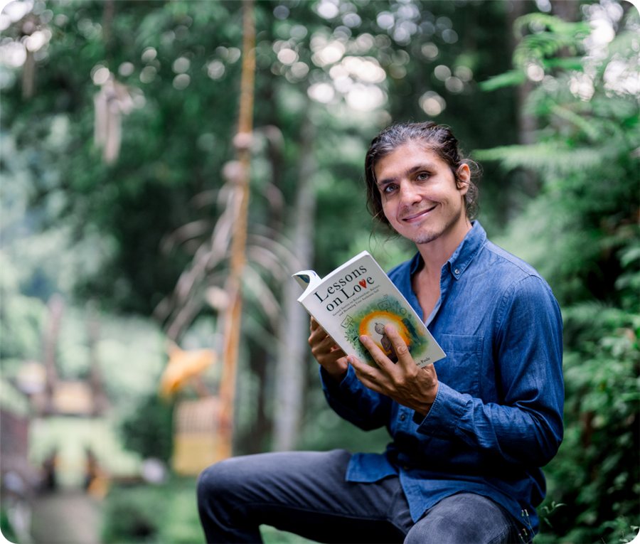 Adam reading Lessons on Love in the forest