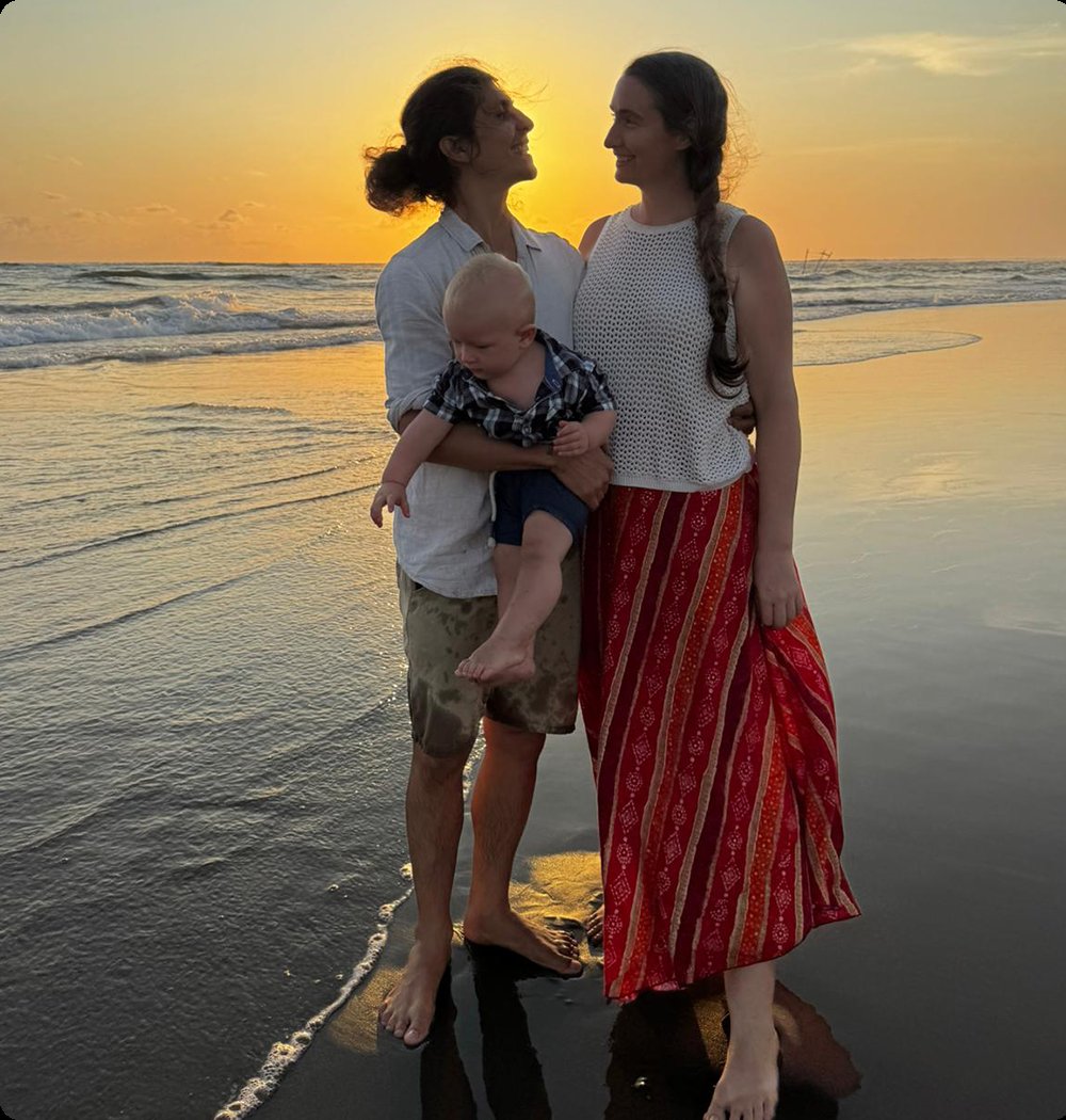 Adam, Andréanne, and their son at sunset on the beach in Bali