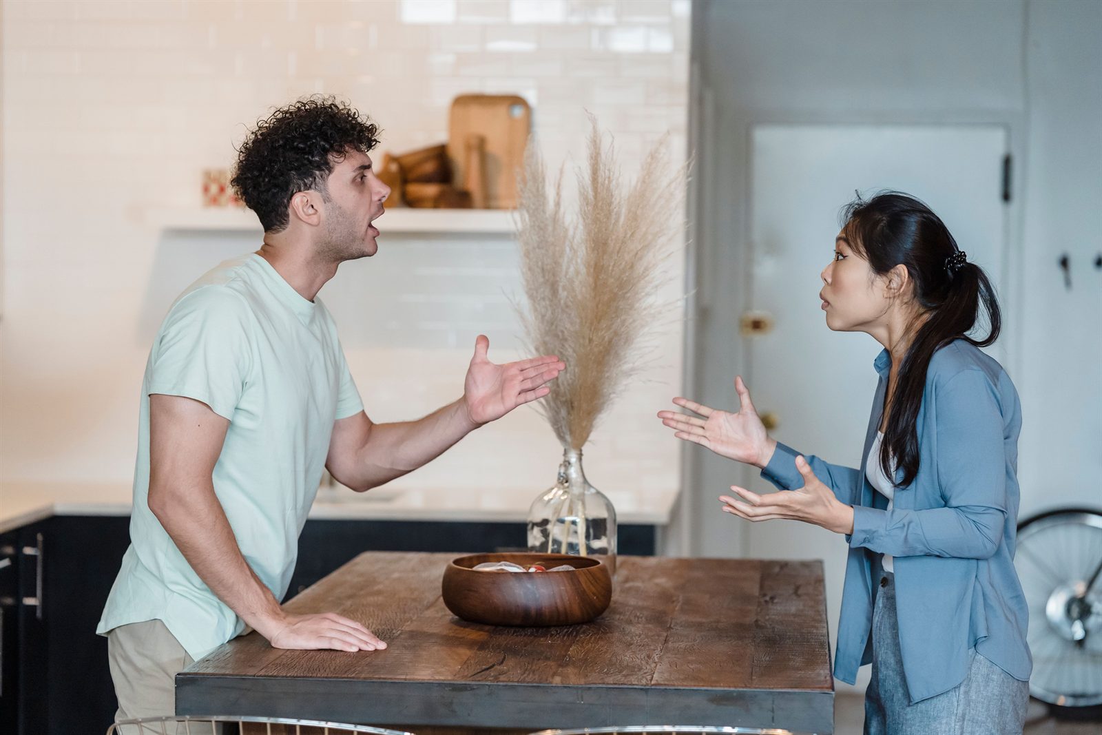 A couple having the same argument again, across the kitchen table