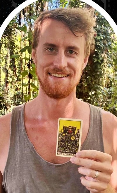 A client smiling, holding the King of Pentacles card